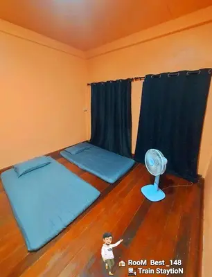 a room with two beds and a fan at best 148 train staytion in Godown