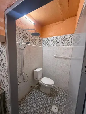 a small bathroom with a toilet and a shower at best 148 train staytion in Godown