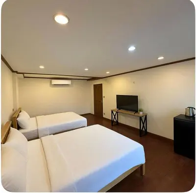 a room with two beds and a flat screen tv at Omalaya Bangkok in Samphanthawong