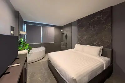 a bedroom with a bed and a bathroom with a tub at HK Villa Resort in Bangkok