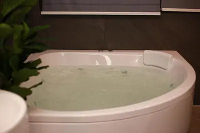 a bath tub filled with water in a bathroom at HK Villa Resort in Bangkok