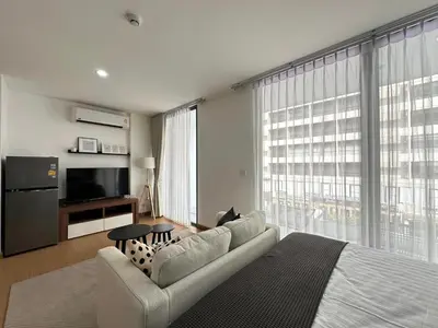 a living room with a couch and a large window at 6th Avenue Sukhumvit BKK 403 BTS Asoke Nana MRT Sukhumvit in Bangkok