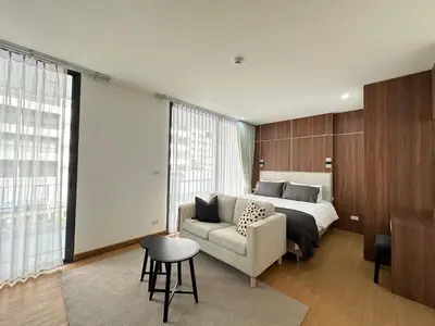 a bedroom with a bed and a couch and a table at 6th Avenue Sukhumvit BKK 403 BTS Asoke Nana MRT Sukhumvit in Bangkok