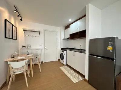 a kitchen and dining room with a table and a refrigerator at 6th Avenue Sukhumvit BKK 403 BTS Asoke Nana MRT Sukhumvit in Bangkok