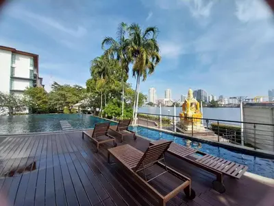 a swimming pool with chairs and a fountain on a building at Riverview Condo Near Icon Siam Hi Speed Internet in Rat Burana