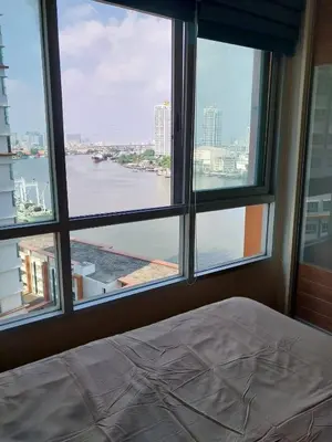 a bedroom with a window looking out at the water at Riverview Condo Near Icon Siam Hi Speed Internet in Rat Burana