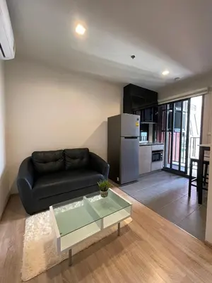 a living room with a black couch and a refrigerator at Private in Bangkapi in Bangkok