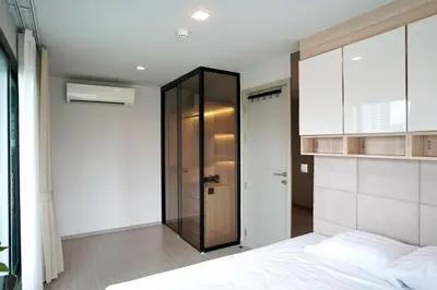 a bedroom with a bed and a glass cabinet at 2 Bedroom Life Ladprao in Bangkok