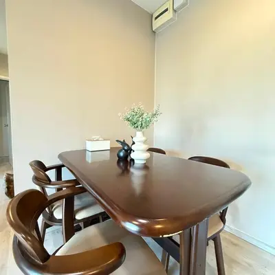 a dining room table with chairs and a vase with flowers at 2 ห้องนอน 2 ห้องน้ำติดเซ็นทรัลเวสเกต นนทบุรี in Ban Bang Krabu
