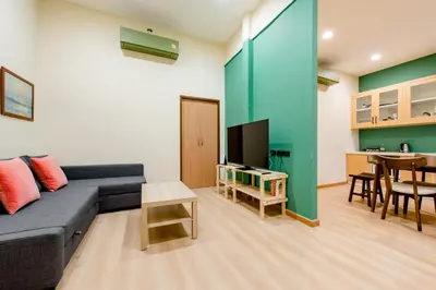 a living room with a blue couch and a table at TermSuk Apt- Banthat Thong in Bangkok