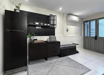 a kitchen with a black refrigerator and a black and white floor at Urban Charm & Unique at KIT-TI's Art Home Sukhumvit in Bangkok