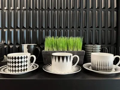 three cups and plates on a table with grass at Urban Charm & Unique at KIT-TI's Art Home Sukhumvit in Bangkok