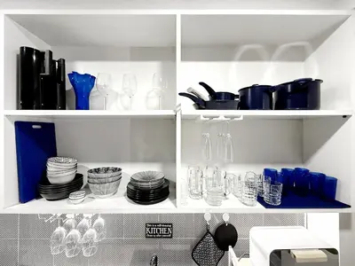 a white cabinet filled with glasses and plates at Urban Charm & Unique at KIT-TI's Art Home Sukhumvit in Bangkok