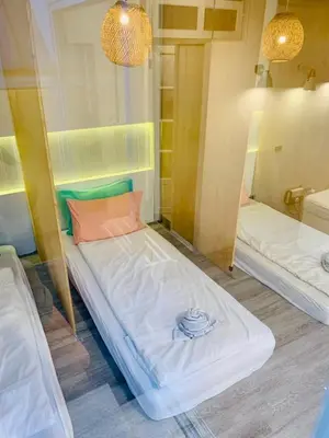 a small room with two beds in it at Loft Rattanakosin Mansion in Bangkok