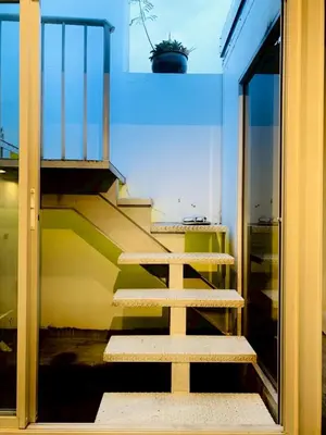 a staircase in a room with a glass door at Loft Rattanakosin Mansion in Bangkok