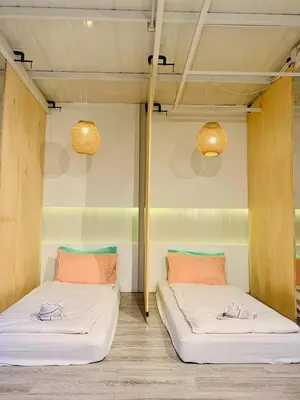 two beds in a room with lights on the wall at Loft Rattanakosin Mansion in Bangkok