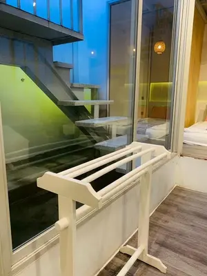 a white bench sitting in front of a window at Loft Rattanakosin Mansion in Bangkok