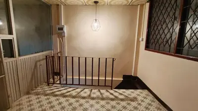 a hallway with a staircase with a pendant light at Rhythm of love in Bangkok