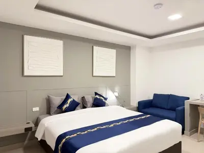 a bedroom with a large bed and a blue chair at UTD8 Hotel and Residence in Bangkok