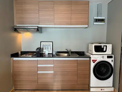 a kitchen with a sink and a washing machine at Noble Remix Thong Lo Long Stay Cozy&Warm Direct access to BTS Pool Gym WiFi in Bangkok