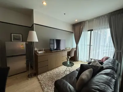 a living room with a couch and a television at Noble Remix Thong Lo Long Stay Cozy&Warm Direct access to BTS Pool Gym WiFi in Bangkok