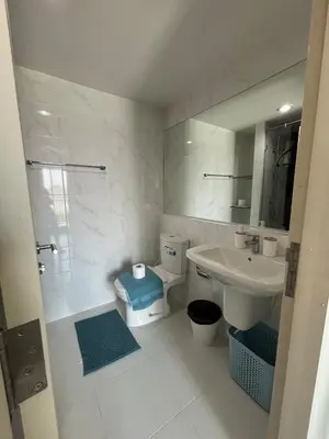 a bathroom with a sink and a toilet and a mirror at Sukhumvit 50 apartment in Bangkok