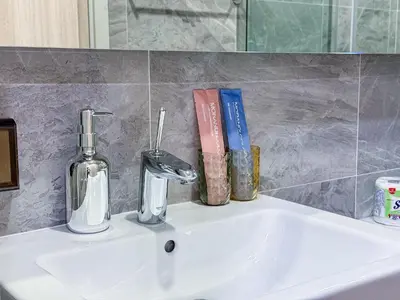 a sink with a bottle of soap and books on it at Luxury Downtown Bangkok 2BR 2BA Sky Pool Gym 5MIN Walk to Siam Paragon in Bangkok