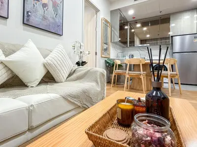a living room with a couch and a table at Luxury Downtown Bangkok 2BR 2BA Sky Pool Gym 5MIN Walk to Siam Paragon in Bangkok
