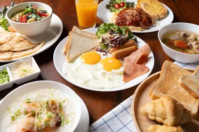 a table with plates of breakfast food on it at Dewan Bangkok in Bangkok