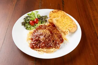 a white plate with spaghetti and a sandwich and bread at Dewan Bangkok in Bangkok