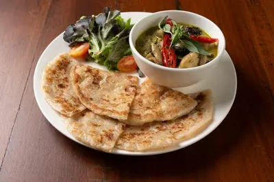a plate of food with a bowl of soup and bread at Dewan Bangkok in Bangkok