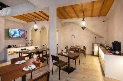 a dining room with tables and chairs and a kitchen at Dewan Bangkok in Bangkok
