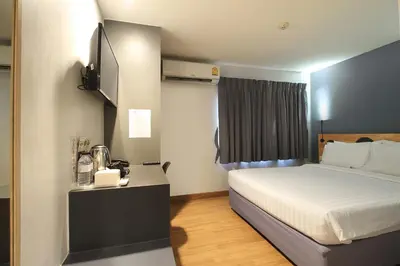 a hotel room with a bed and a television at Mybed Sathorn Hotel in Bangkok