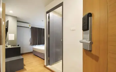 a room with a door with a mirror and a bed at Mybed Sathorn Hotel in Bangkok