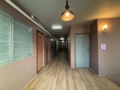 an empty hallway of a building with a door and a window at Onnut36 Apartment Panasan in Amphoe Phra Khanong
