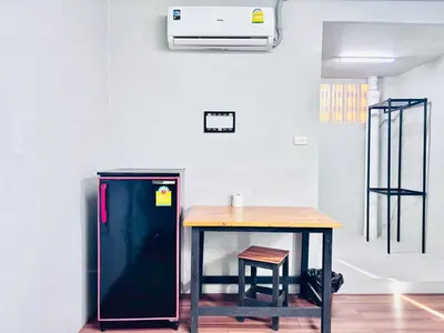 a black refrigerator next to a table in a room at Onnut36 Apartment Panasan in Amphoe Phra Khanong