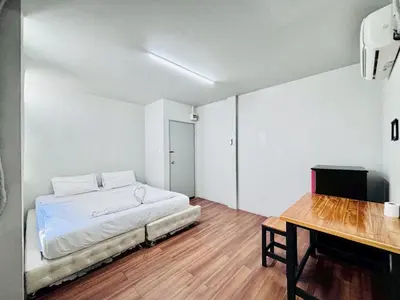 a white bedroom with a bed and a desk at Onnut36 Apartment Panasan in Amphoe Phra Khanong
