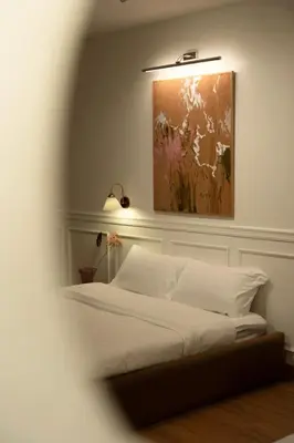 a bedroom with a bed with a painting on the wall at Roni House Thonglor in Bangkok