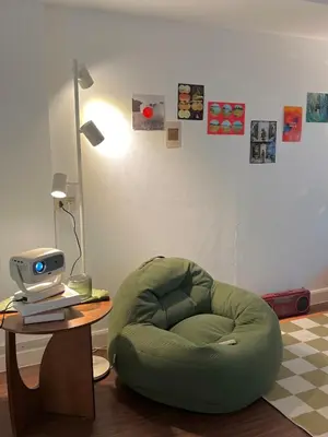 a green chair sitting next to a table with a computer at Roni House Thonglor in Bangkok