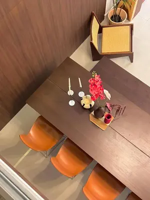 a wooden table with orange chairs and flowers on it at Roni House Thonglor in Bangkok