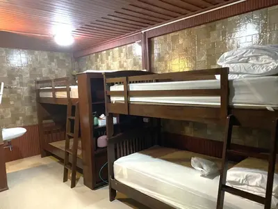 a room with three bunk beds and a bathroom at Sukhum Ban Songthai in Bangkok