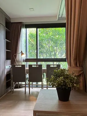 a living room with a table and chairs and a large window at \u901a\u7f85\u5929\u9435\u7ad9\u6b65\u884c\u4e09\u5206\u9418\u7cbe\u88dd\u6f62\u5168\u5957\u516c\u5bd3 in Bangkok