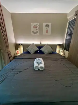 a pair of slippers sitting on top of a bed at \u901a\u7f85\u5929\u9435\u7ad9\u6b65\u884c\u4e09\u5206\u9418\u7cbe\u88dd\u6f62\u5168\u5957\u516c\u5bd3 in Bangkok