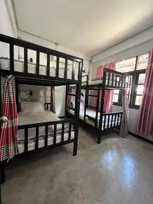 a bedroom with two bunk beds and two windows at BNK89 Hostel in Bangkok