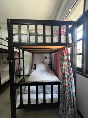 two bunk beds in a room with a bed at BNK89 Hostel in Bangkok