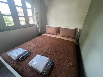 a small bedroom with a bed with two bottles on it at BNK89 Hostel in Bangkok
