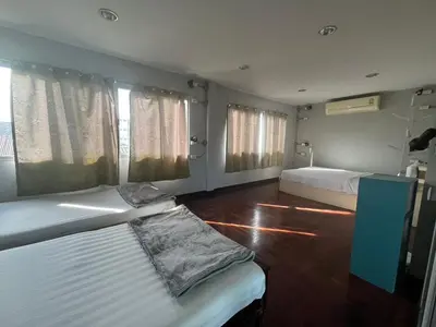 a bedroom with two beds and two windows at BNK89 Hostel in Bangkok