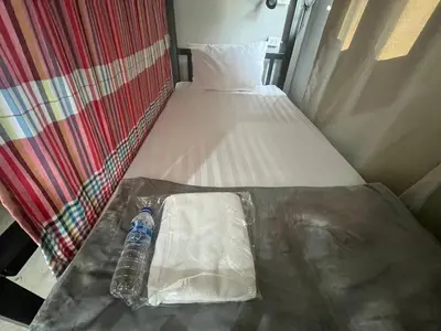 a bottle of water sitting on top of a bed at BNK89 Hostel in Bangkok
