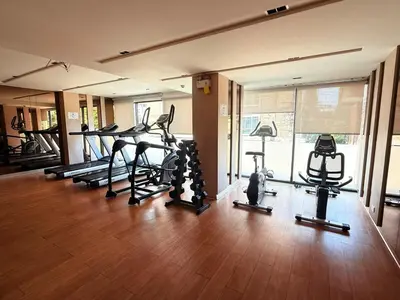 a gym with a bunch of treadmills and ellipticals at The Monti Condo in Bangkok