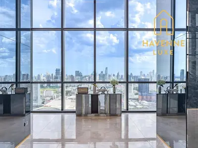 a lobby with large windows and a view of the city at City Luxe Condo 5-Min Walk to Siam Paragon Modern Stay in Bangkok